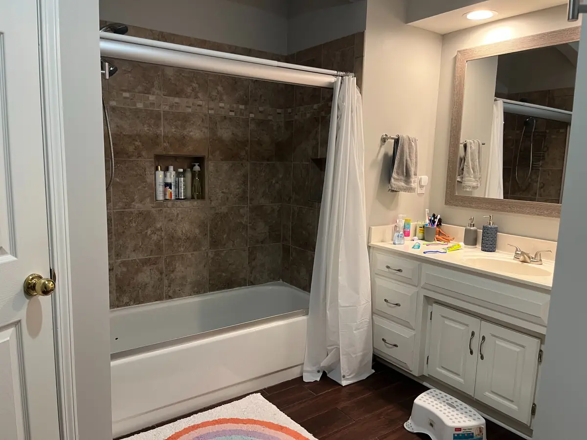 Primary bathroom with corner tub and twin vanities — before